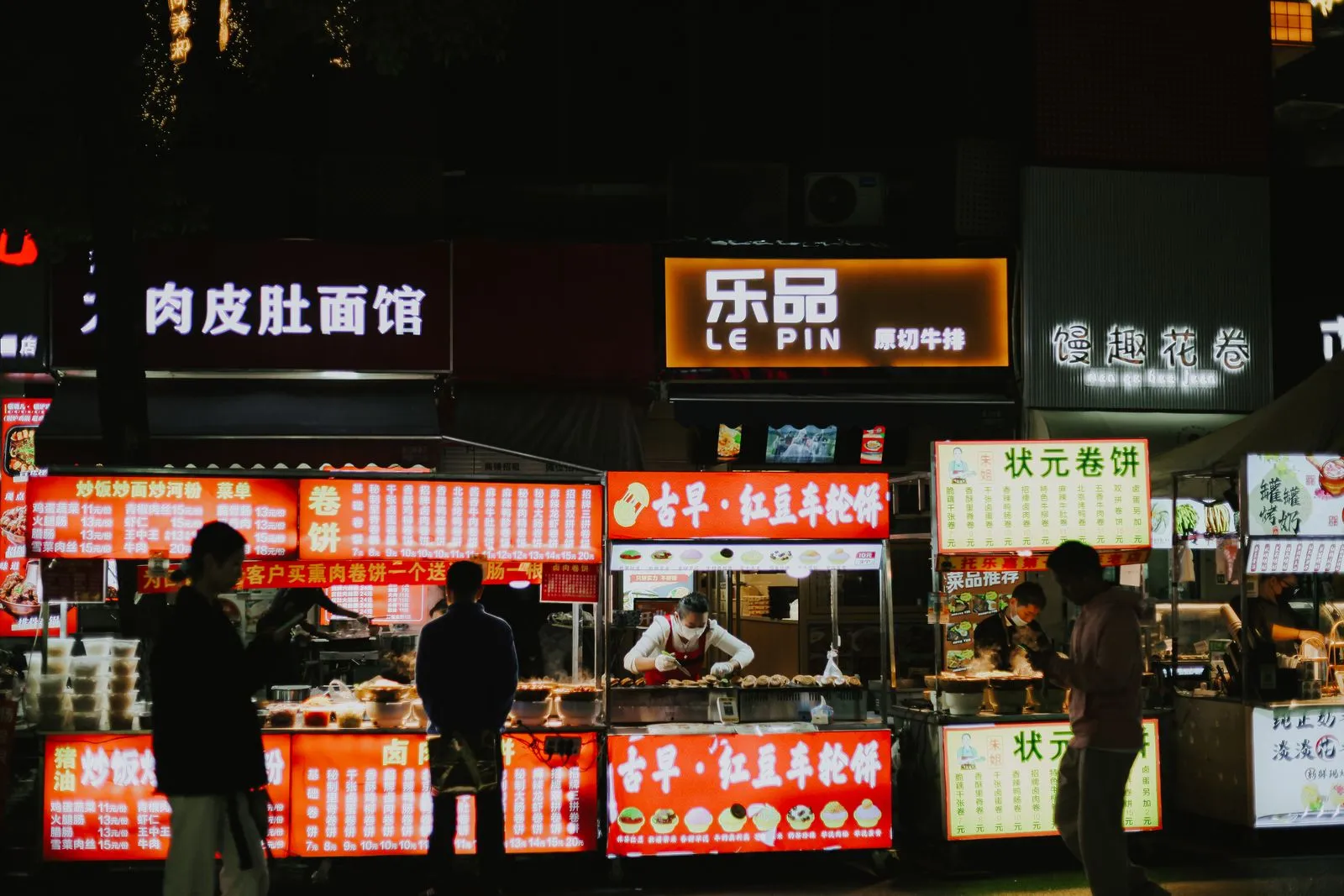 Street food stalls glowing at a Yunnan night market